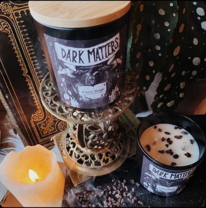 Two Dark Matters vegan scented candles and one lit candle